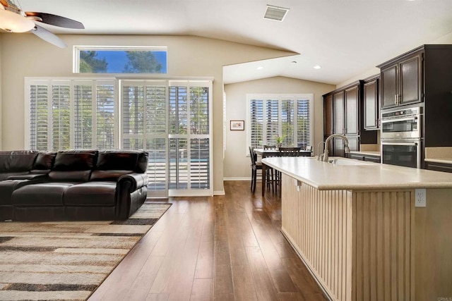 living room with lofted ceiling, dark wood-type flooring, visible vents, recessed lighting, and a ceiling fan