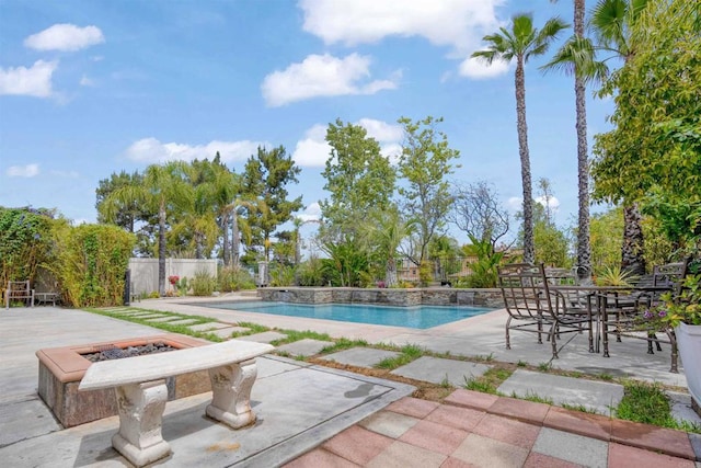 view of swimming pool featuring an outdoor fire pit, a patio, fence, and a fenced in pool