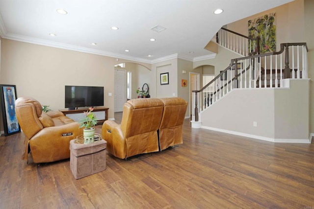 living area featuring wood finished floors, stairway, arched walkways, ornamental molding, and recessed lighting