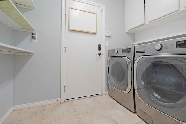 washroom with cabinet space, baseboards, and washer and dryer