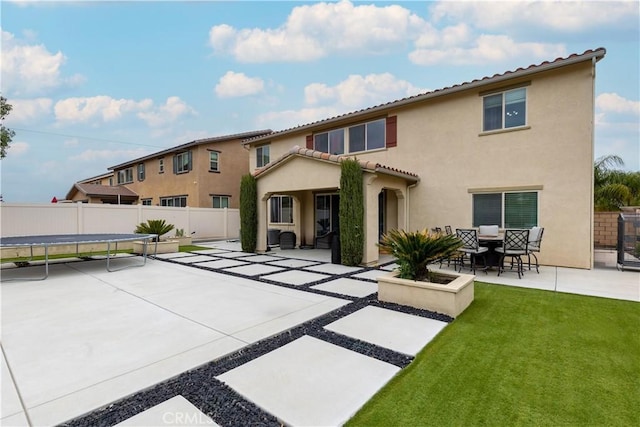36696 Pavic Ct, Lake Elsinore, CA 92532 - rear view of property featuring a patio, stucco siding, a fenced backyard, a trampoline, and a tiled roof