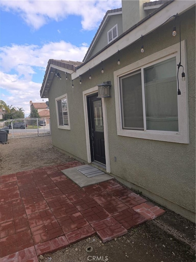 4990 Padre Ave, Rancho Cucamonga, CA 91739 - property entrance featuring a patio, stucco siding, and fence