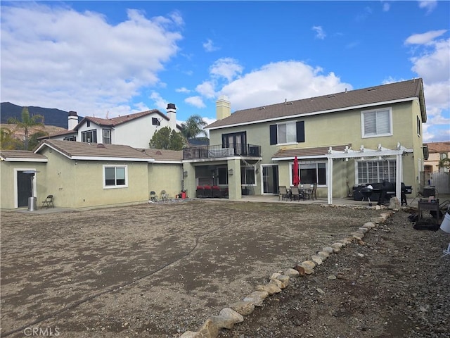 4990 Padre Ave, Rancho Cucamonga, CA 91739 - rear view of house with a pergola, a patio area, stucco siding, and a balcony