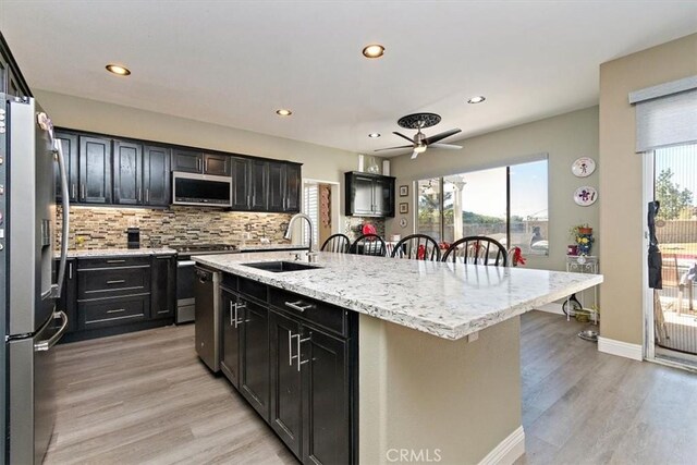 4990 Padre Ave, Rancho Cucamonga, CA 91739 - kitchen with a sink, stainless steel appliances, light wood finished floors, backsplash, and a ceiling fan
