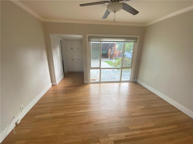 spare room with ceiling fan, crown molding, baseboards, and light wood-type flooring