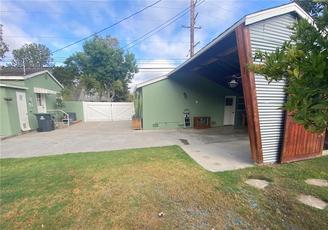 rear view of house with a patio, a gate, crawl space, fence, and a lawn