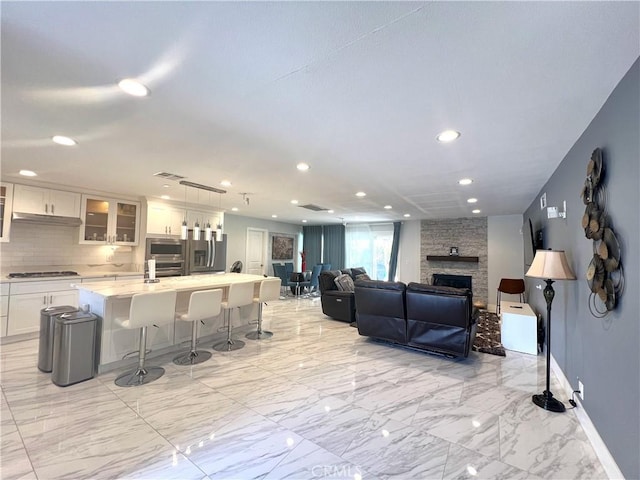 6051 Summerdale Dr, Huntington Beach, CA 92647 - living room with marble finish floor, visible vents, recessed lighting, a fireplace, and baseboards