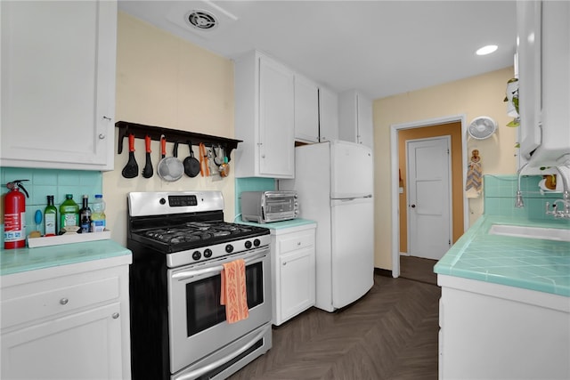 7111 Texhoma Ave, Van Nuys, CA 91406 - kitchen featuring stainless steel gas range oven, freestanding refrigerator, white cabinets, a sink, and recessed lighting