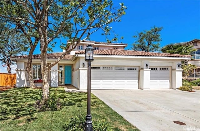 mediterranean / spanish-style house featuring an attached garage, driveway, stucco siding, a front yard, and a tiled roof