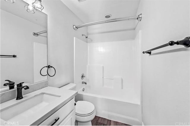 bathroom featuring vanity, toilet, tub / shower combination, and wood finished floors