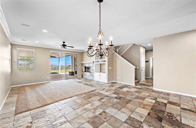 unfurnished living room with ceiling fan with notable chandelier, recessed lighting, crown molding, a premium fireplace, and baseboards