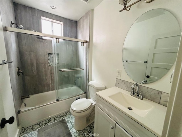 bathroom with toilet, tile patterned flooring, vanity, and combined bath / shower with glass door