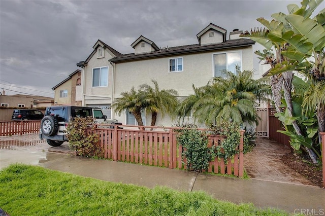 view of front of property featuring stucco siding and fence