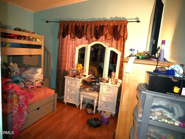 bedroom with crown molding and wood finished floors
