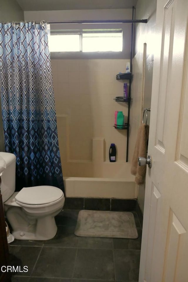 bathroom with toilet, tile patterned flooring, and shower / bath combo with shower curtain