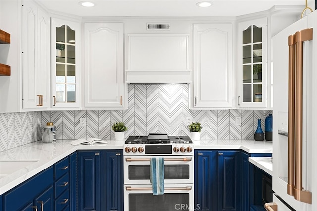 kitchen featuring blue cabinets, double oven range, white cabinetry, and white fridge with ice dispenser