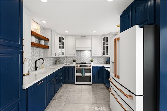 kitchen with premium appliances, blue cabinets, a sink, open shelves, and backsplash