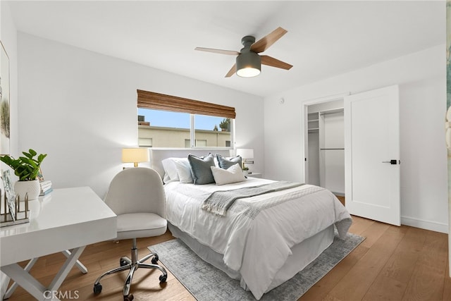 bedroom with a ceiling fan, baseboards, and light wood-style flooring
