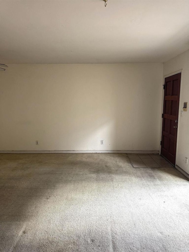 unfurnished room featuring light carpet and baseboards