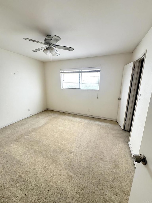 spare room featuring light colored carpet and ceiling fan