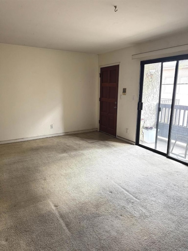 carpeted empty room with baseboards