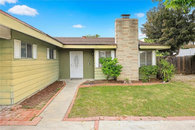 3540 S Flemington Dr, West Covina, CA 91792 - view of exterior entry with a yard, a chimney, and fence