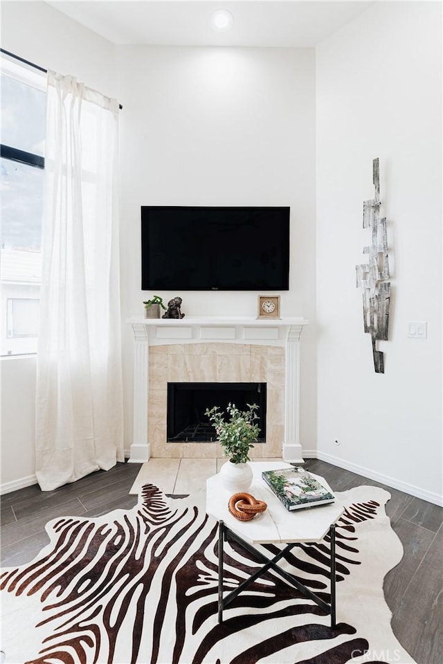 living room with recessed lighting, baseboards, a tiled fireplace, and wood finished floors