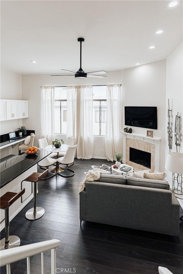 living room with a fireplace, ceiling fan, dark wood-style floors, and recessed lighting