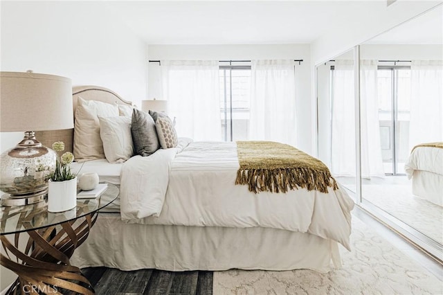 bedroom with access to exterior and wood finished floors