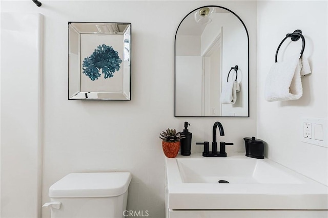 half bathroom with vanity and toilet