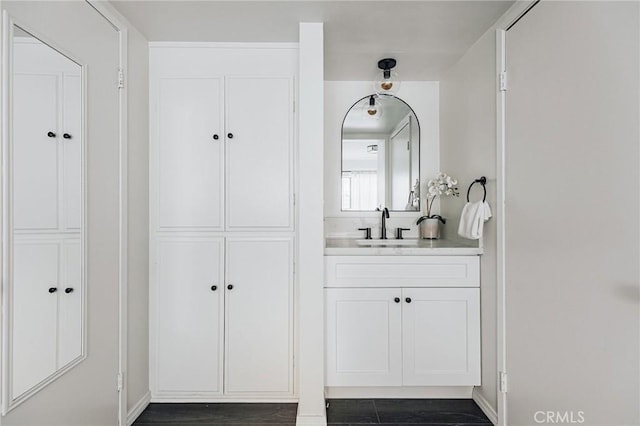 bathroom featuring baseboards, vanity, and wood finished floors