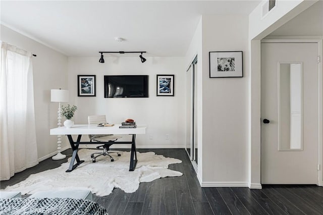 office space featuring baseboards, visible vents, track lighting, and dark wood-type flooring