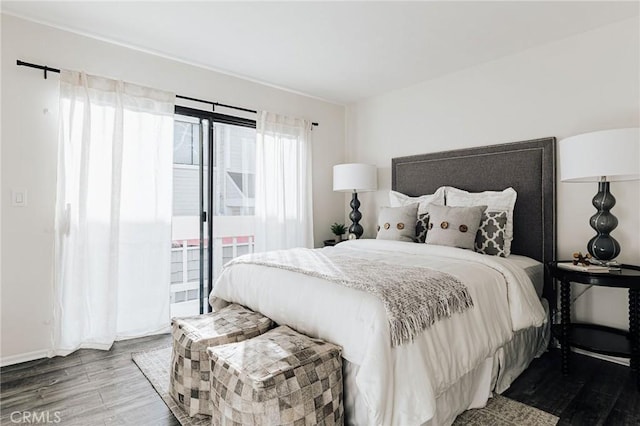 bedroom with baseboards, wood finished floors, and access to exterior