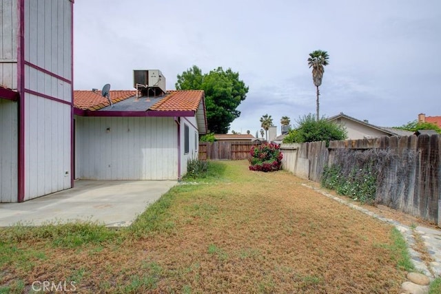 view of yard with a fenced backyard, a patio, and central AC unit