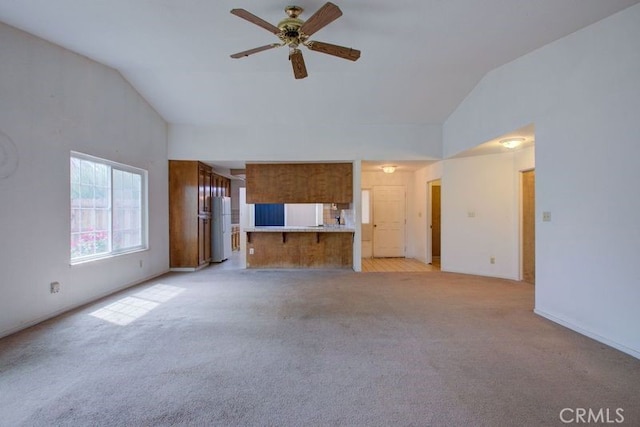 unfurnished living room featuring light colored carpet, baseboards, ceiling fan, and high vaulted ceiling