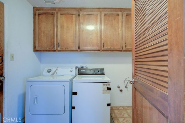 laundry area featuring washer and clothes dryer and cabinet space