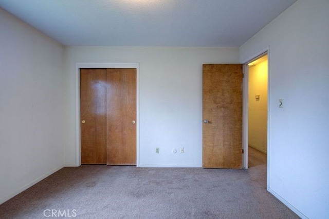unfurnished bedroom with baseboards, a closet, and carpet floors