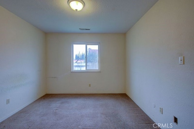 unfurnished room with carpet floors and visible vents