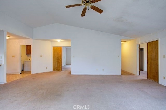 unfurnished living room featuring a ceiling fan, light carpet, washer / clothes dryer, and vaulted ceiling