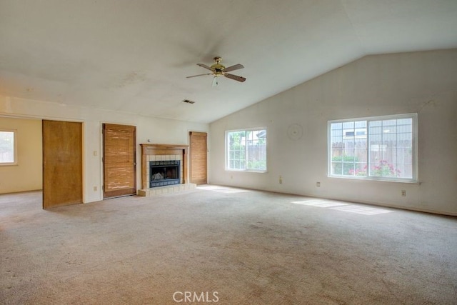 unfurnished living room featuring carpet flooring, a tiled fireplace, visible vents, ceiling fan, and lofted ceiling