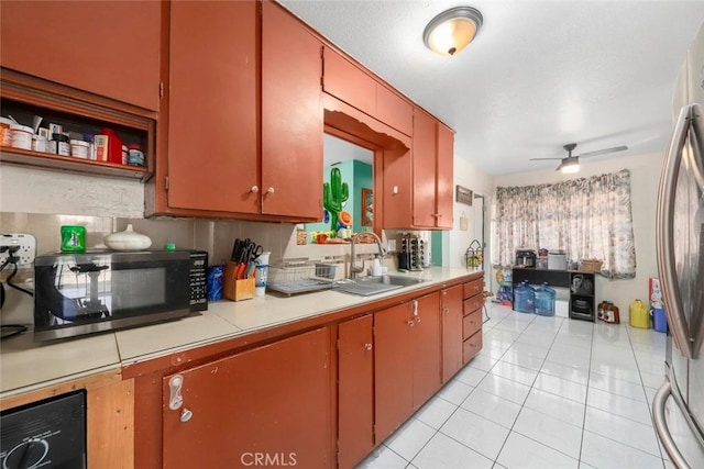 423 Landsford St, Lancaster, CA 93535 - kitchen with light tile patterned floors, a sink, black microwave, stainless steel fridge, and light countertops