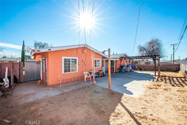 423 Landsford St, Lancaster, CA 93535 - back of house with a patio area, stucco siding, a pergola, a fenced backyard, and a gate