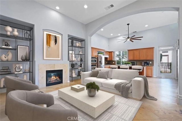 12931 Runway Rd, Playa Vista, CA 90094 - living room featuring arched walkways, recessed lighting, a ceiling fan, a premium fireplace, and light tile patterned floors