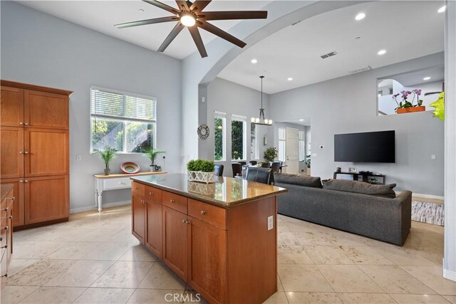 12931 Runway Rd, Playa Vista, CA 90094 - kitchen with ceiling fan, a center island, brown cabinets, arched walkways, and recessed lighting