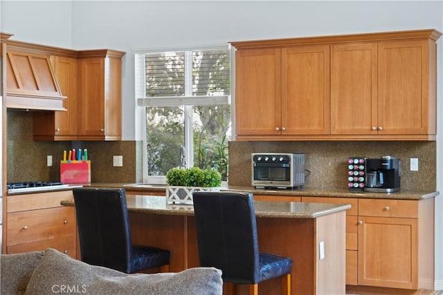 12931 Runway Rd, Playa Vista, CA 90094 - kitchen featuring a kitchen breakfast bar, gas stovetop, tasteful backsplash, and stone counters