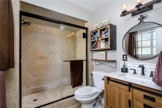 full bath featuring a stall shower, vanity, toilet, and tasteful backsplash