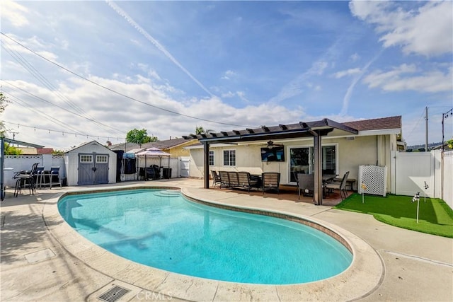 view of pool with an outdoor hangout area, a patio, a storage shed, and a fenced backyard