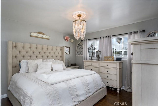 bedroom featuring dark wood-style floors and a notable chandelier