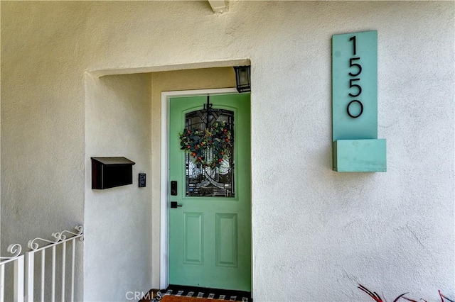 view of exterior entry featuring stucco siding