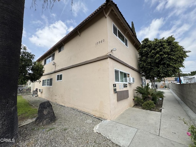 view of home's exterior featuring fence, stucco siding, and a patio area